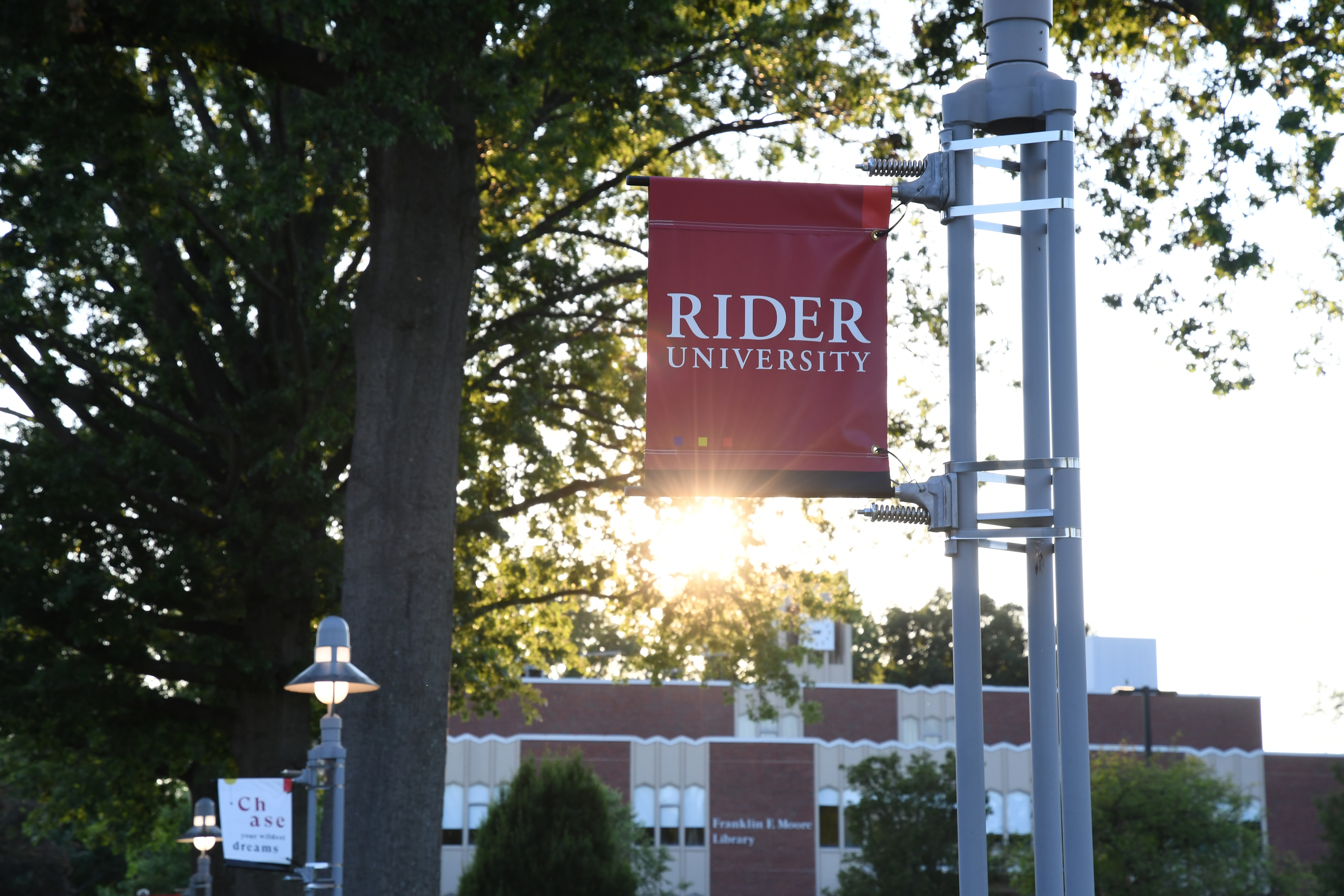 Rider sign at sunset in front of Moore library