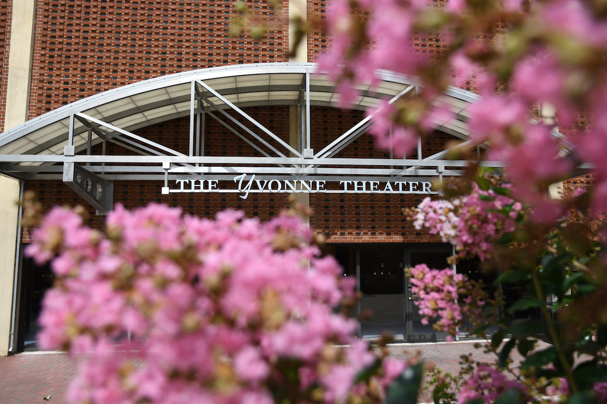 Facade of the Yvonne Theater in the background of pink blossoms
