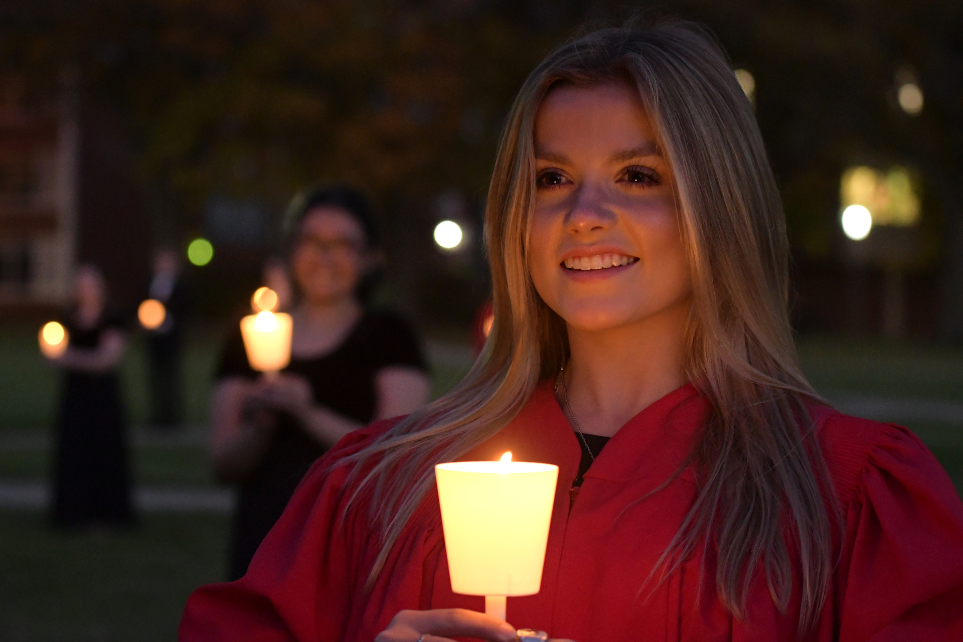 Choir student holding candle.