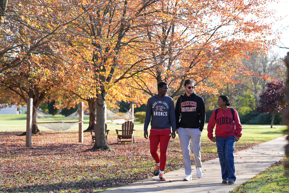 Three students walk on campus