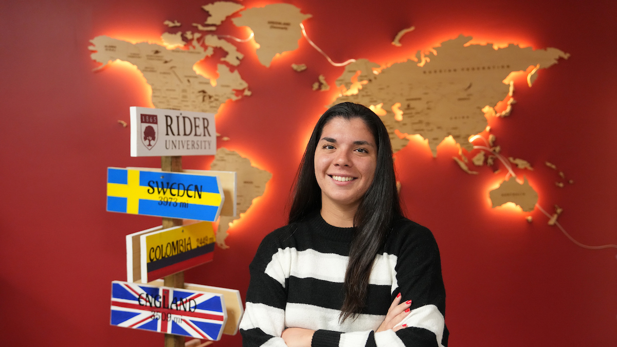 Rider students in front of world map and world flags