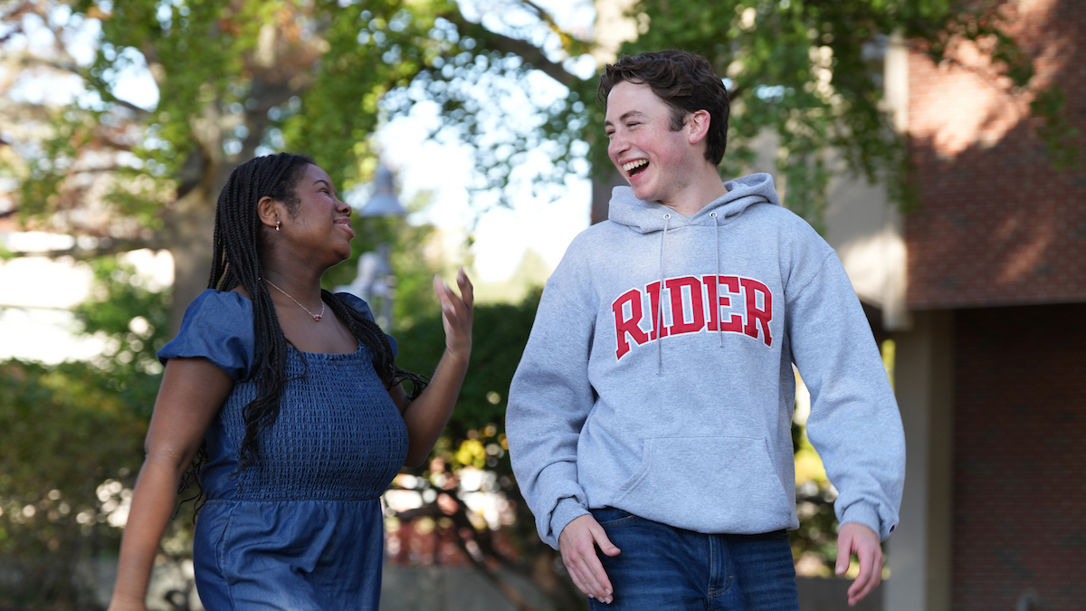 Two Rider students walking on campus laughing