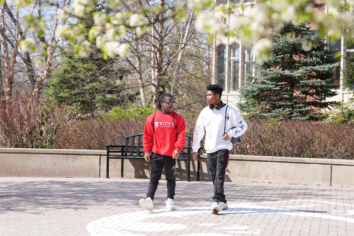 Two students walk near Moore Library