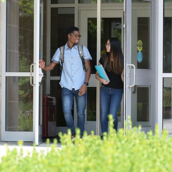 Two students exiting Lynch Adler Hall