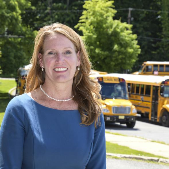 Kari McGann, Class of 2020 in front of school busses