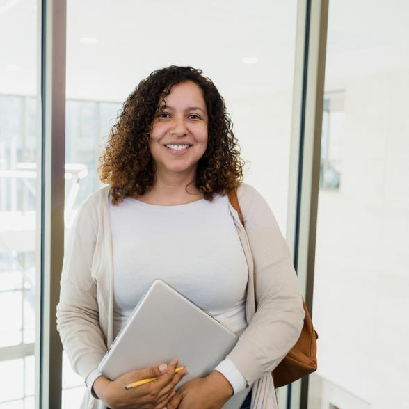 Woman holding computer smiles