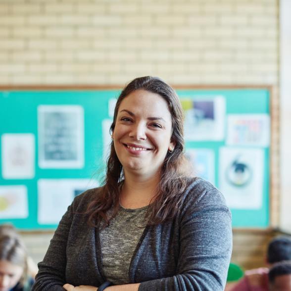 Teacher smiling in front of children in classroom