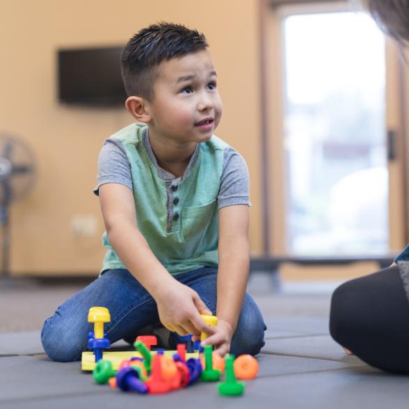 Child plays with toys with supervision