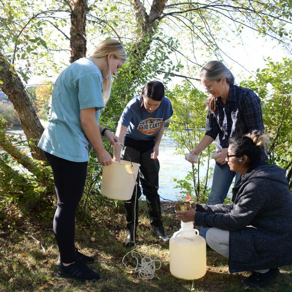 Group of students getting samples of water outdoors