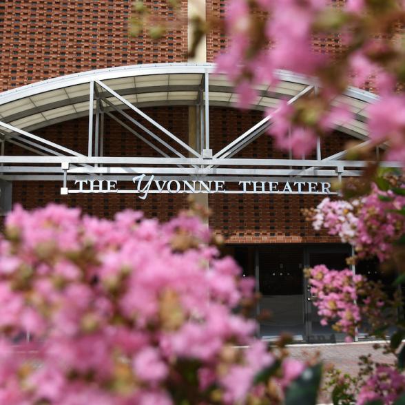 Facade of the Yvonne Theater in the background of pink blossoms