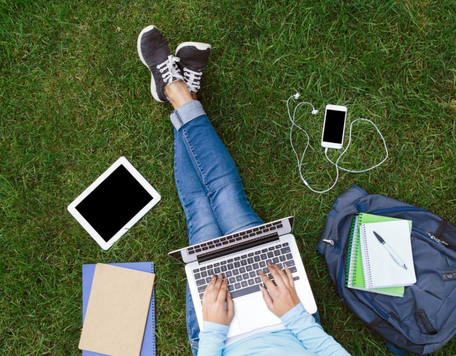 Student works outside on laptop 