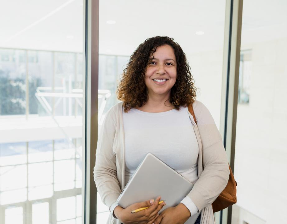 Woman holding computer smiles