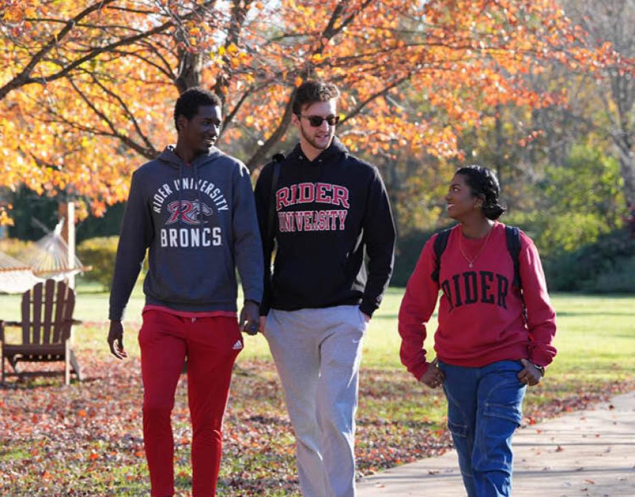 three students walking on campus in the fall
