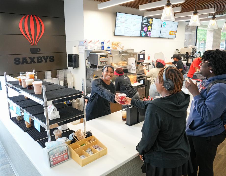 Student handing students Saxbys drink