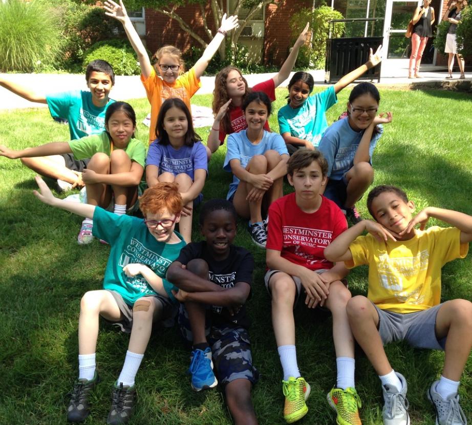 Pre-teen summer camp children posing with arms up