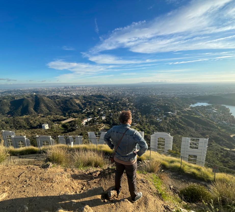 Student standing behind Hollywood sign looking out